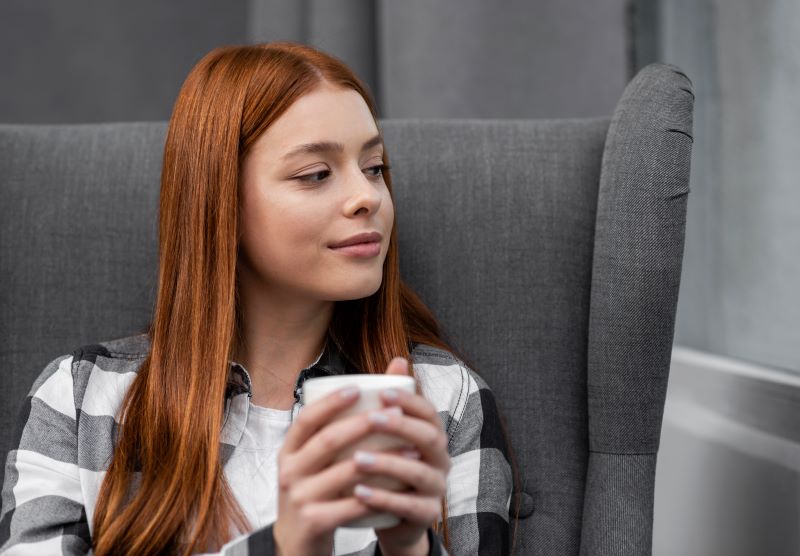 Woman sitting on a comfortable chair with a cup of tea