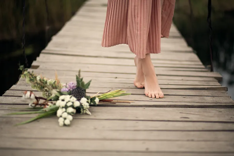Woman walking barefoot in a calm natural setting representing ADHD self-compassion and gentle self-acceptance