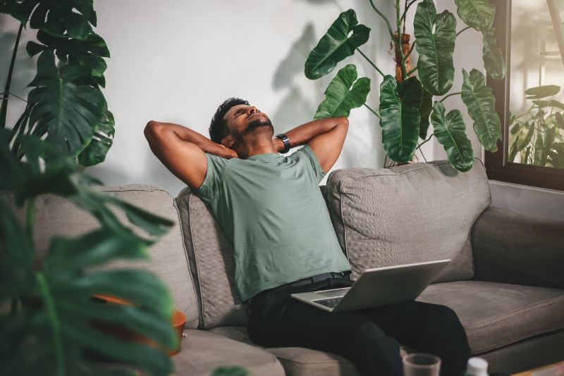 Man sitting with laptop looking mentally exhausted after working from home with ADHD