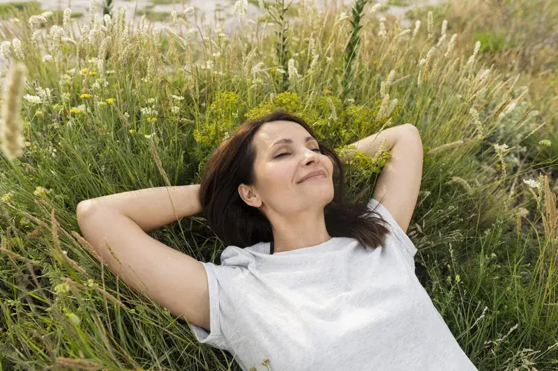 Woman lying peacefully in long grass, reflecting on learning to trust myself with ADHD.
