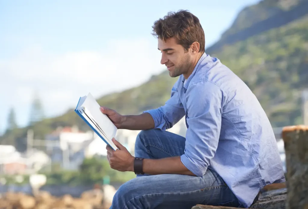 Man sitting outdoors journaling and reflecting