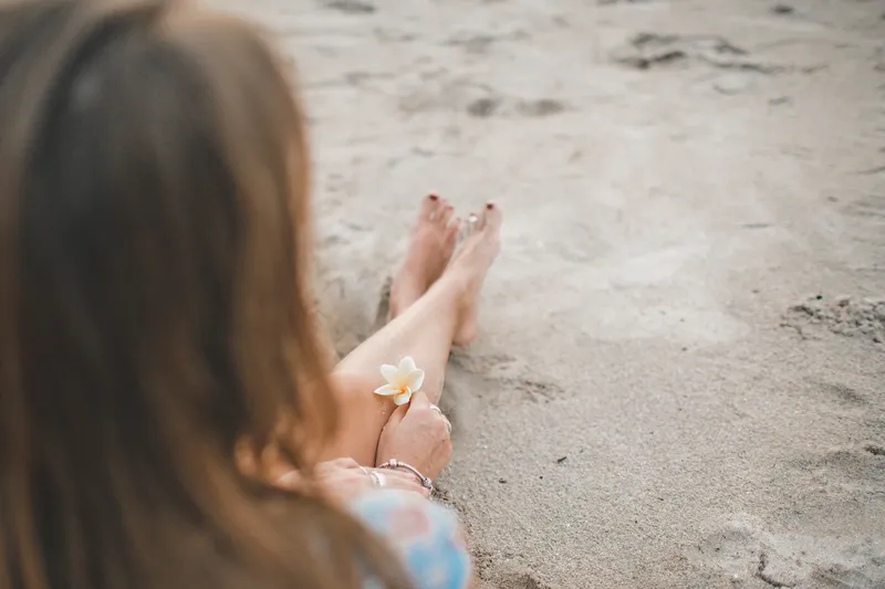 A person sitting quietly on a beach, representing the intense thoughts and emotional pull that can come with limerence and ADHD.