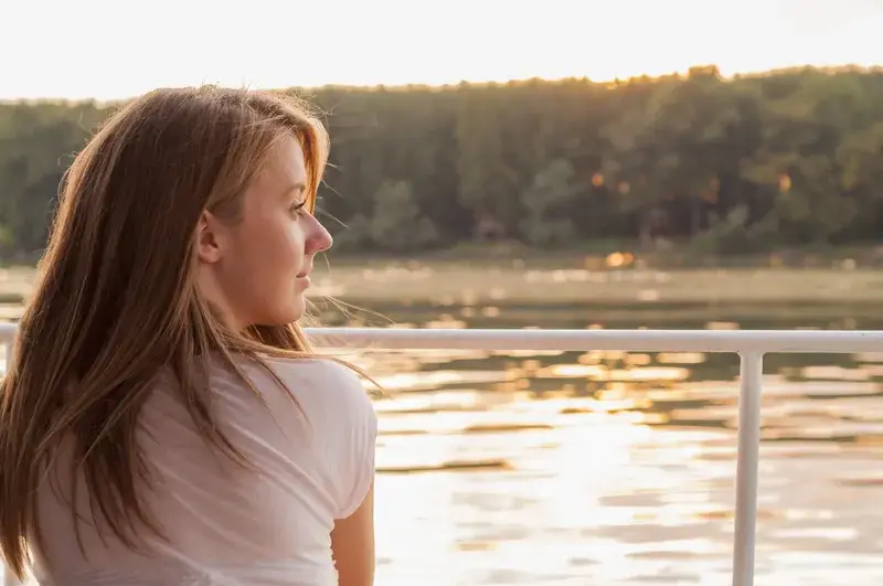 Woman sitting by the water deep in thought, reflecting the emotional intensity of limerence with ADHD.