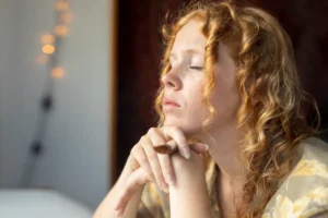 Woman gazing thoughtfully out of a window, absorbed in deep reflection and emotional focus