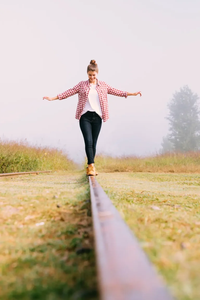 woman walking on a thin ledge representing balancing life with ADHD