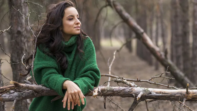 Woman standing in woodland looking thoughtful representing ADHD masking emotional exhaustion and hiding struggles