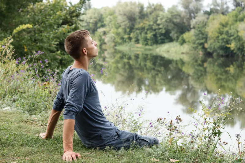Adult reflecting beside a lake during ADHD workplace overwhelm