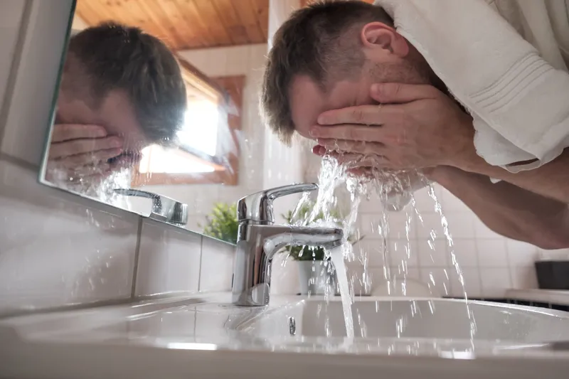 A close-up of someone splashing water on their face, representing the effort it can take to get started and get things done with ADHD.