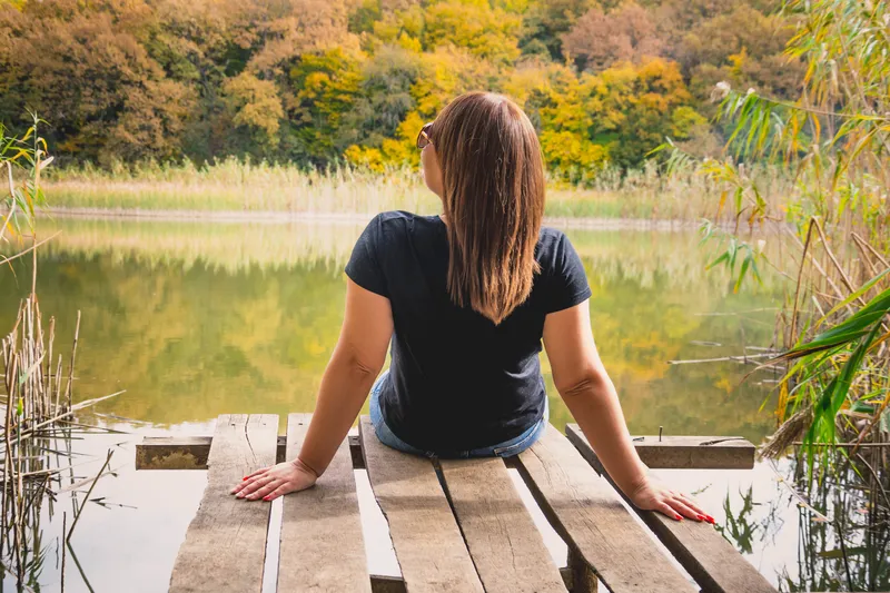Woman journalling outdoors during ADHD coaching self-reflection practice