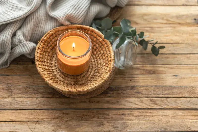 Lit candle and soft blanket representing ADHD self-compassion, self-kindness and quiet reflection.