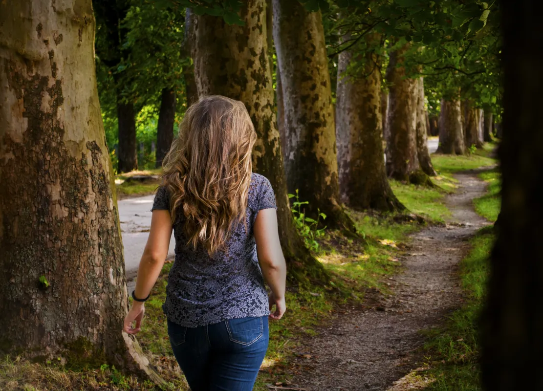 Person walking along a woodland path, representing moving forward through ADHD programmes and personal growth.