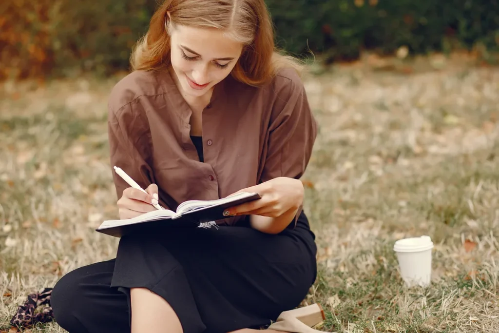 Woman writing in a notebook representing ADHD strategies that make life easier.