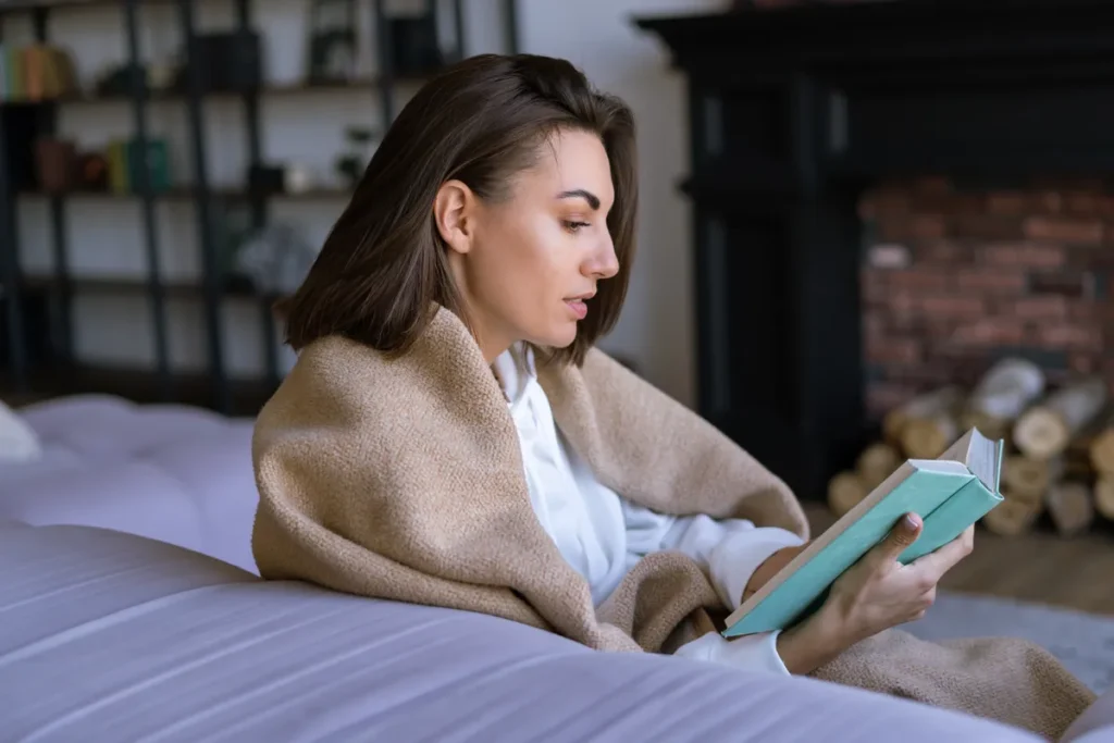 Woman reading at home representing what ADHD coaching can help with.